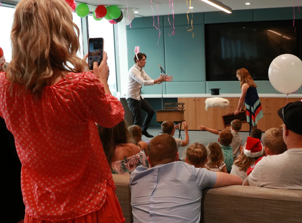 Magician's rabbit wows at investment firm's family Christmas party.